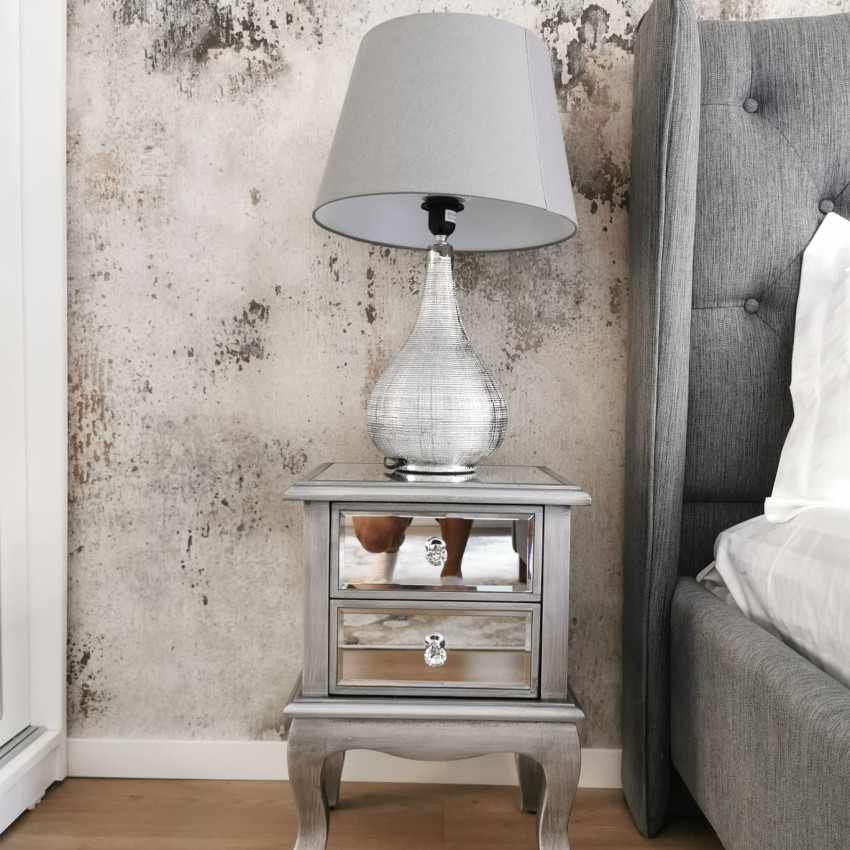 Tapet 3D Patina, cu aspect de beton, într-un dormitor cu pat dublu, cu lenjerie de pat albastră, perne decorative și o canapea cu o pătură de blană
