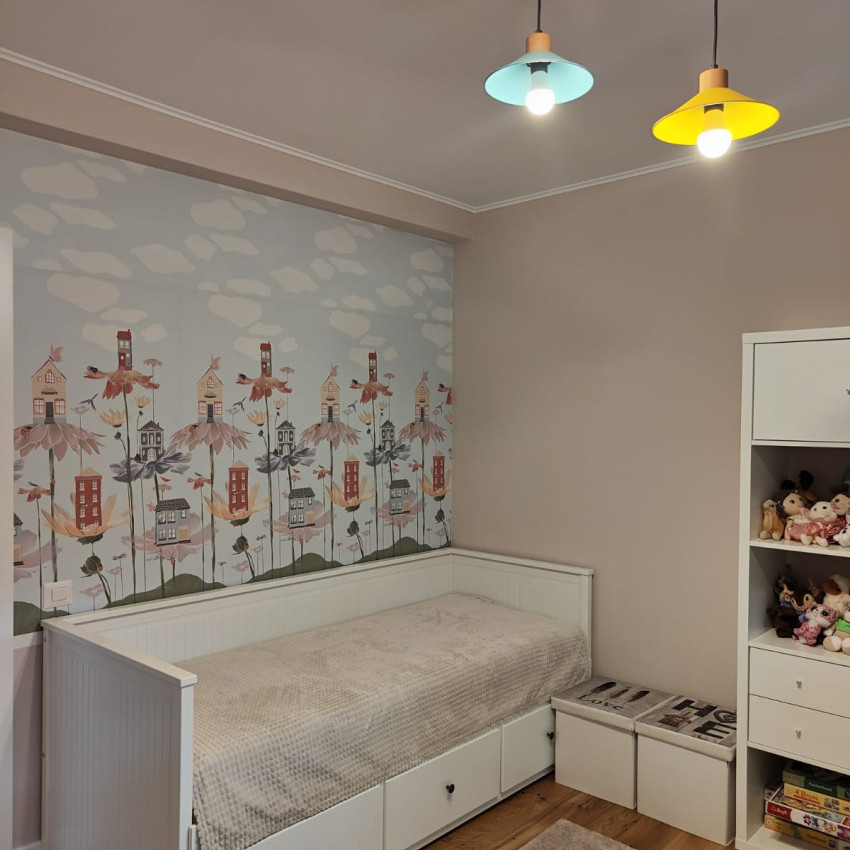 Tapet cu design floral cu case mici, pe un fundal albastru cu nori