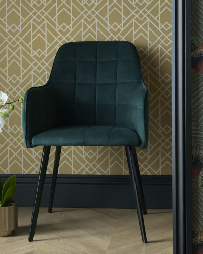 Mustard Yellow Luxury Geometric tapet cu model geometric pe fundal galben, cu un scaun verde si o planta cu flori albe in ghiveci auriu, in fata tapetului.