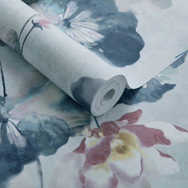 Tapet Water Lilies Blue Dusk Luxury Floral cu flori de nuferi albastre pe fond albastru deschis. Tapetul este decorat cu flori mari si delicate. Se vede un chiuveta alba cu robinet auriu in fata tapetului.