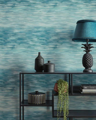Tapet geometric modern cu un design abstract în nuanțe de verde mineral. Tapetul este prezentat pe un perete, cu o canapea, o măsuță de cafea și o lampă în fața sa.