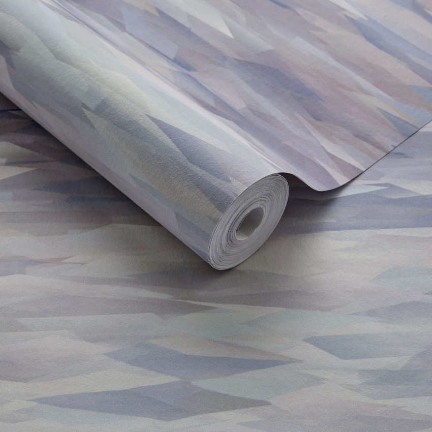 Tapet geometric modern cu un design abstract în nuanțe de verde mineral. Tapetul este prezentat pe un perete, cu o canapea, o măsuță de cafea și o lampă în fața sa.