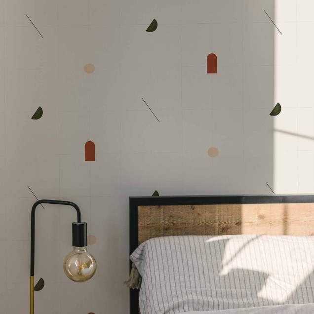 Tapet cu modele geometrice moderne in culori teracota, verde si bej, asezat pe un perete in spatele unui mobilier de living.