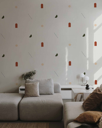 Tapet cu modele geometrice moderne in culori teracota, verde si bej, asezat pe un perete in spatele unui mobilier de living.