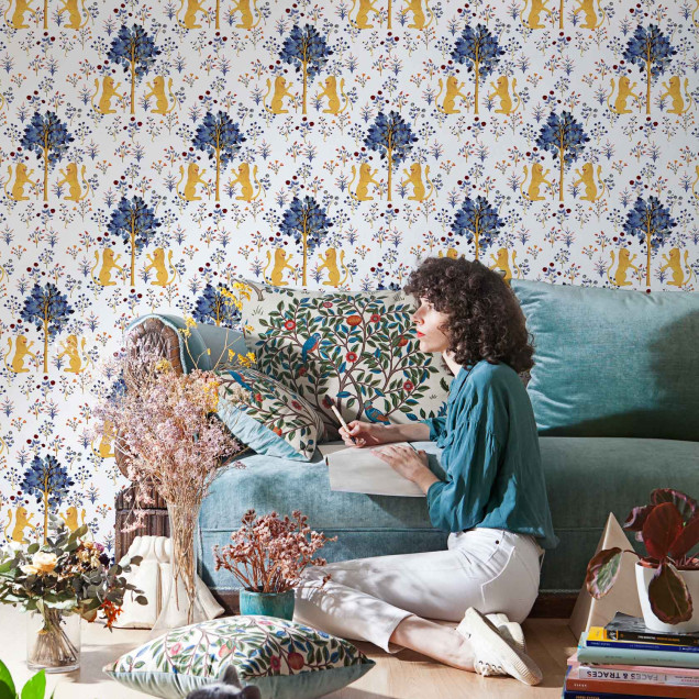 Tapet alb pur cu un design inspirat din tapiserii medievale, prezentând lei galbeni și flori albastre și roșii.