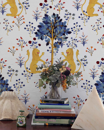 Tapet alb pur cu un design inspirat din tapiserii medievale, prezentând lei galbeni și flori albastre și roșii.