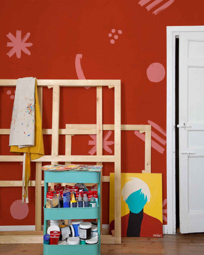 Tapet rosu cu forme geometrice roz si un atelier de artist in fata