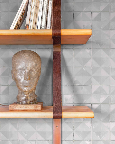 Tapet cu model geometric modern, nuanță deschisă, pe un perete cu rafturi și decorațiuni.