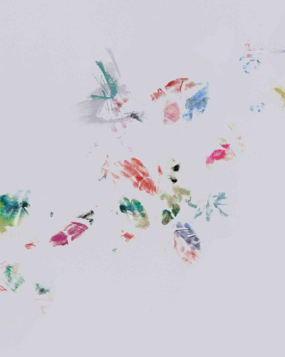 Fototapet cu tușe de culoare abstracte pe un perete gri, alături de un fotoliu vintage și elemente de studio artistic.