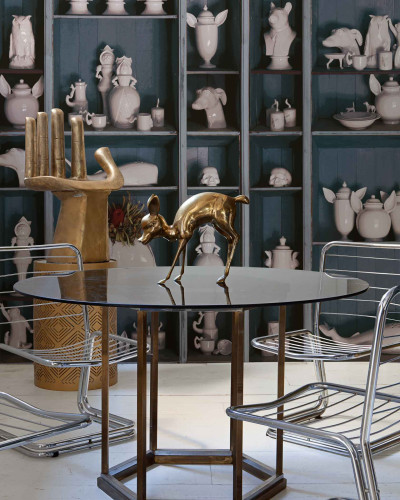 Tapet cu design ceramic faunistic, prezentând diverse obiecte decorative ceramice în formă de animale și figuri, expuse pe rafturi.