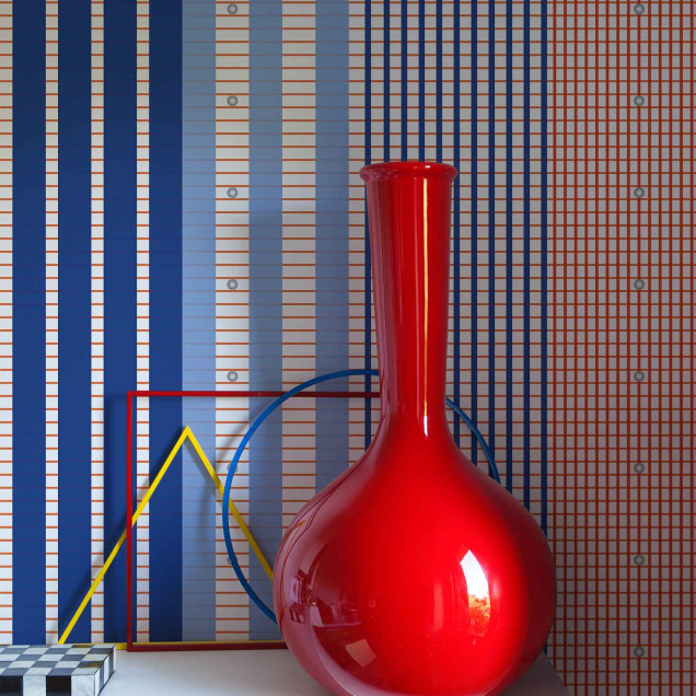 Tapet geometric cu dungi albastre, crem si linii portocalii, asezat pe peretele unei sufragerii moderne.
