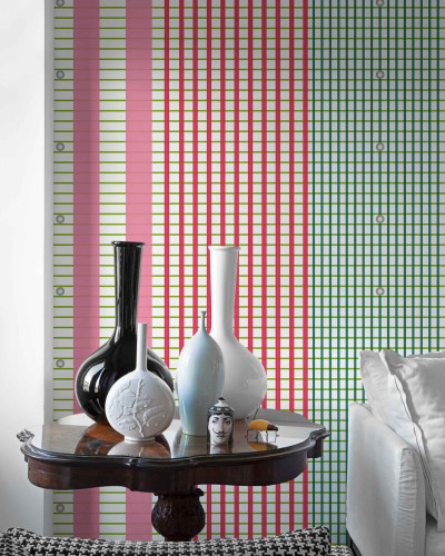 Tapet cu dungi verticale si orizontale in culori roz, rosu si verde, asezat in spatele unui mobilier