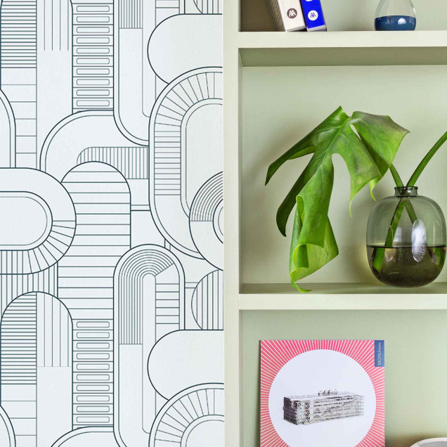 Tapet cu model geometric abstract în nuanțe de gri și alb, aplicat pe un perete din spatele unui set de canapele gri și a unei măsuțe de cafea negre.
