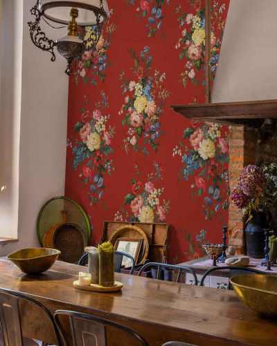 Tapet cu un model bogat de flori colorate pe un fond roșu aprins, într-o sală de mese cu mobilier rustic și o fereastră mare.