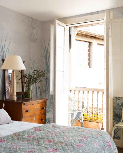 Tapet cu un design botanic detaliat, prezentând stuf și o pasăre în stil acuarelă, într-un dormitor modern.