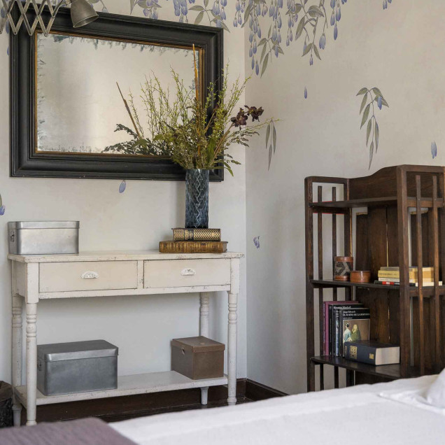 Tapet floral liliac pe un perete într-o cameră luminoasă.