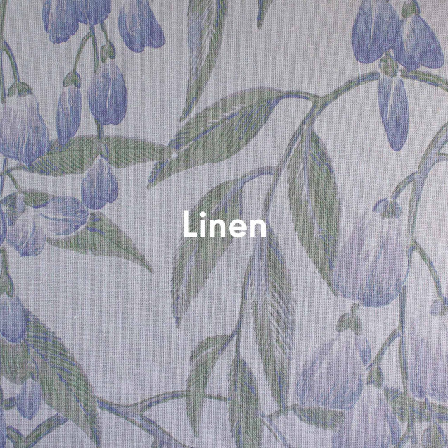 Tapet floral liliac pe un perete într-o cameră luminoasă.
