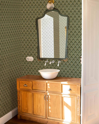 Tapet floral verde smarald într-o baie cu mobilier vintage