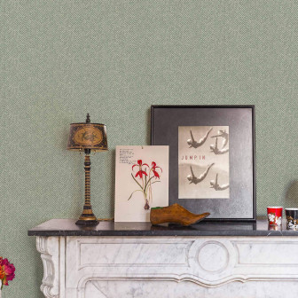 Tapet verde cu model subtil în zig-zag într-o cameră decorată cu șemineu și obiecte decorative vintage.