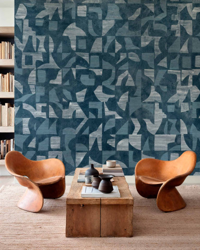 Tapet abstract geometric în nuanțe de albastru și argintiu, aplicat pe un perete într-un living modern.