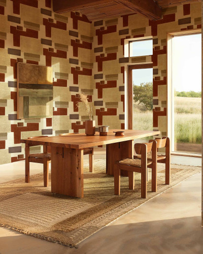 Tapet cu model geometric abstract in nuante de teracota si bej, aplicat pe peretii unei sali de mese rustice.