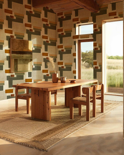 Tapet cu model geometric abstract in culori pamantii intr-un living modern cu masa din lemn si scaune
