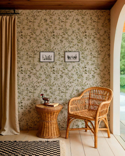 Tapet cu model floral cu frunze verzi, într-un decor rustic cu mobilier din ratan și draperii bej.