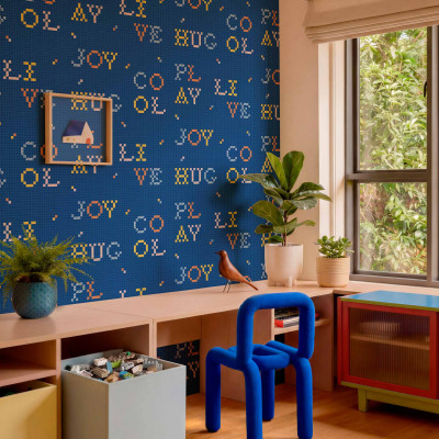 Tapet cu litere colorate in stil pixelat pe fundal albastru indigo intr-o camera de zi moderna.