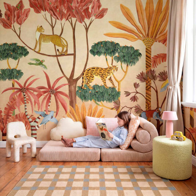 Copil citind pe o canapea în fața unui tapet cu design de junglă, cu feline și plante tropicale.