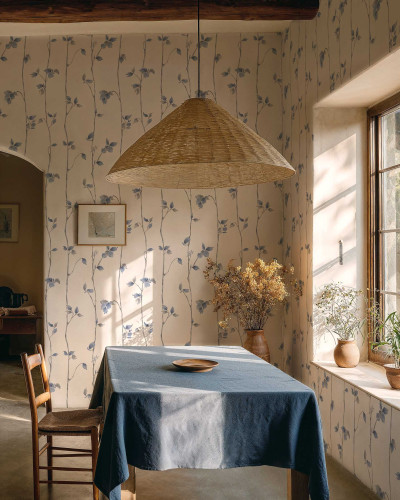 Tapet cu model floral albastru pe fundal crem, prezentând ramuri și frunze stilizate într-un decor de cameră