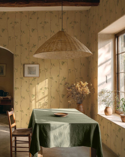 Tapet cu model de ramuri si frunze in nuante de ocru, intr-un interior rustic cu masa si scaun