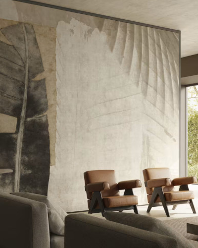 Fototapet cu design abstract de frunze tropicale în culori neutre, într-un living modern cu fotolii din piele.