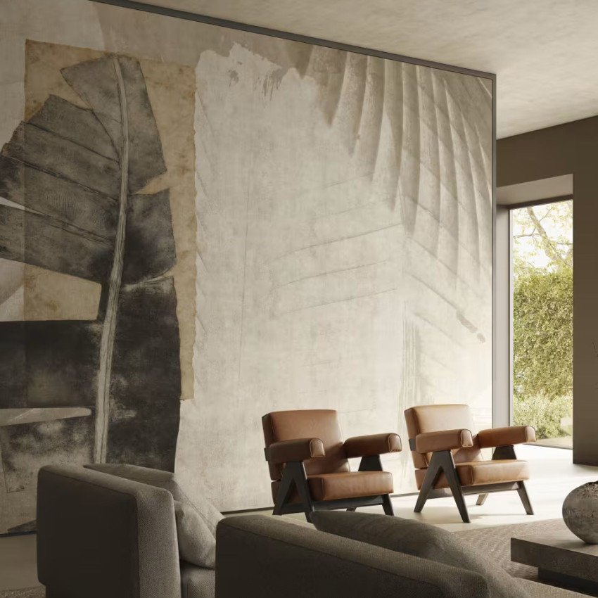 Fototapet cu design abstract de frunze tropicale în culori neutre, într-un living modern cu fotolii din piele.