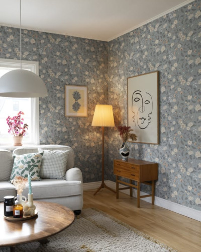 Tapet floral Till Karin Folklore Blue, cu flori delicate și o paletă de culori blândă, instalat într-un living modern.