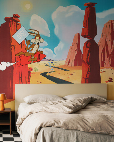 Fototapet Looney Tunes 202 cu Wile E. Coyote pe o rachetă și Road Runner în deșert, într-o cameră decorată modern.