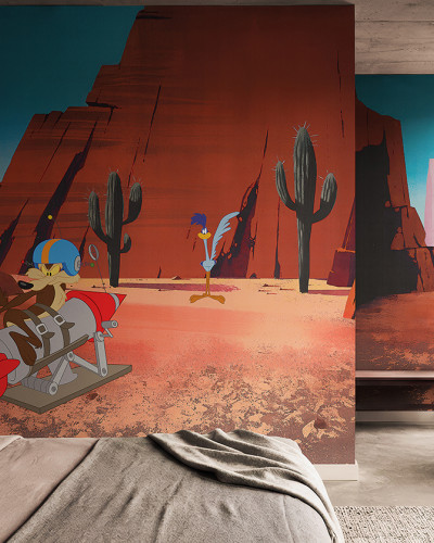 Fototapet Looney Tunes 205 într-un dormitor modern, prezentând pe Wile E. Coyote pe o rachetă și pe Road Runner în deșertul cu cactuși.