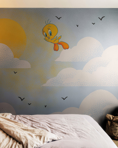 Fototapet Looney Tunes 218 cu Tweety zburând pe cer printre nori și soare, într-un dormitor modern de copii cu pat și accesorii.