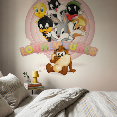 Fototapet Looney Tunes 220 instalat într-un dormitor modern cu pat și noptieră, prezentând Bugs Bunny, Daffy, Tweety, Sylvester, Lola Bunny, Marvin Marțianul și Diavolul Tasmanian pe un fundal roz deschis.