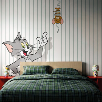 Fototapet Tom și Jerry 107 într-o cameră de copii, cu Tom zâmbitor și Jerry suspendat pe o panglică, pe un fundal cu dungi verticale verzi pal și albe. Pat cu așternuturi în carouri verzi, noptiere roșii.