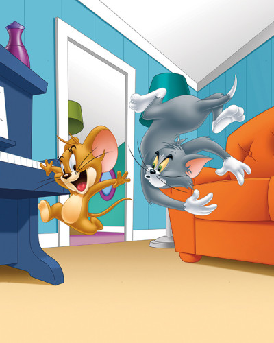 Fototapet Tom și Jerry 123 pe peretele unei camere de copii, arătând pe Tom și Jerry în mijlocul unei curse amuzante lângă un pian și o canapea portocalie, aducând veselie și culoare spațiului.