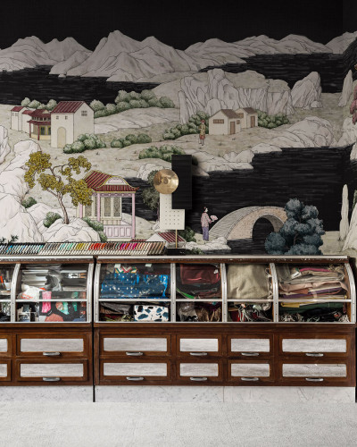 Tapet cu design japonez, Kimono Tale Books / Okobo (negru). Peisaj artistic cu munți, copaci, punte tradițională și clădiri în stil kimono. Culori vibrante și detalii pictate manual. Fundal negru elegant.