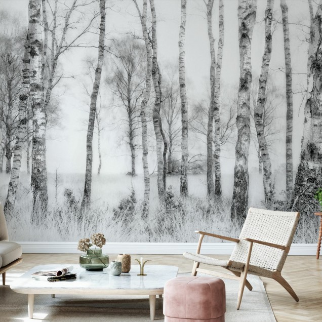 Imagine cu un Black and White Photowall în decorul unei camere de zi moderne, cu un canapea gri, o masă de cafea și două pufuri. Tapetul prezintă o imagine cu copaci în nuanțe de gri.