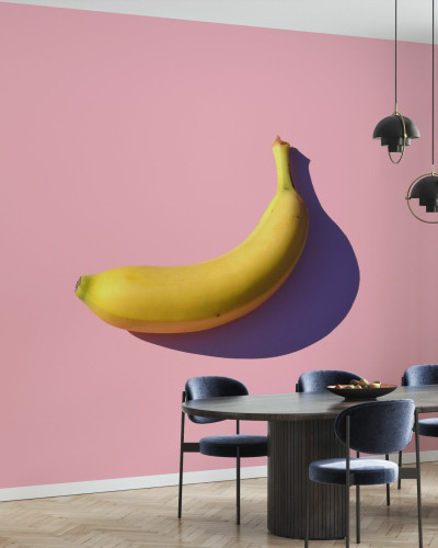 Fototapet cu o banană pe un fundal roz, perfect pentru un living, bucătărie sau dormitor.