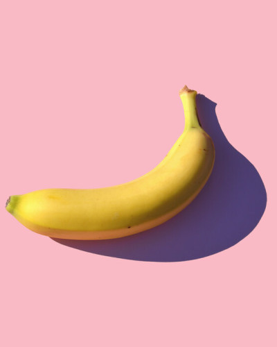 Fototapet cu o banană pe un fundal roz, perfect pentru un living, bucătărie sau dormitor.