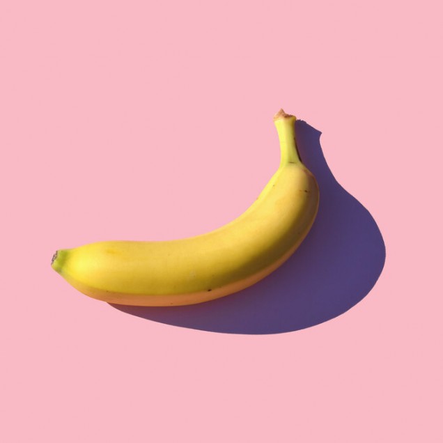 Fototapet cu o banană pe un fundal roz, perfect pentru un living, bucătărie sau dormitor.