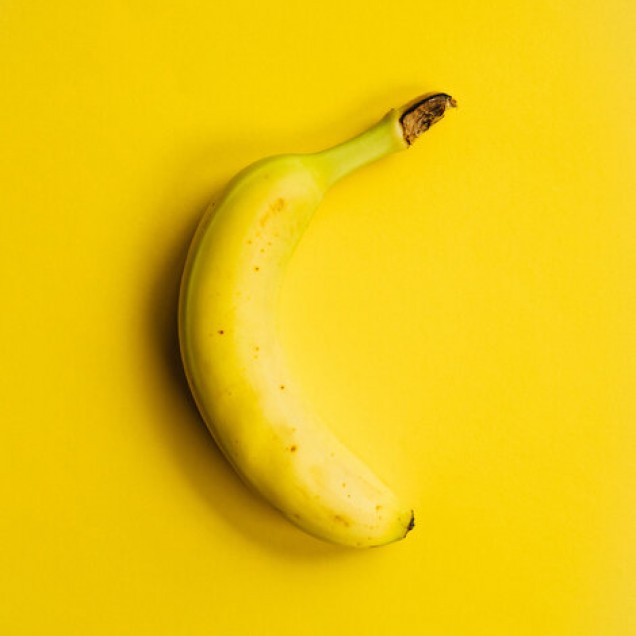 Yellow Banana - Tapet cu un design modern si minimalist, prezentand o banana galbena pe un fundal galben.