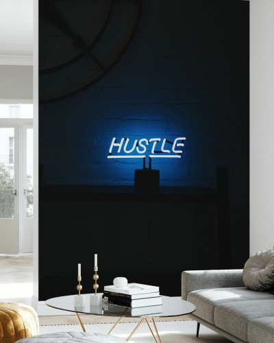 Hustle Neon Sign Photowall, tapet cu un semn neon luminos pe un fundal întunecat, ideal pentru a crea o atmosferă modernă și vibrantă.