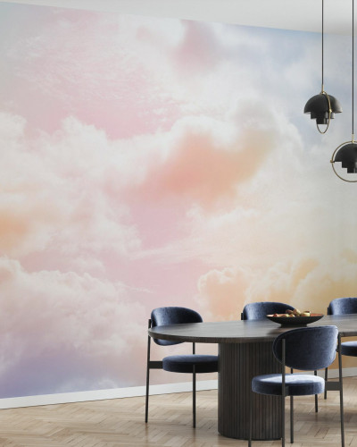 Imaginea de fundal Clouds in the Sky, prezintă nori albi pufoși pe un fundal colorat pastelat, care se transformă de la roz la galben, în timp ce lumina soarelui se reflectă ușor prin ei.