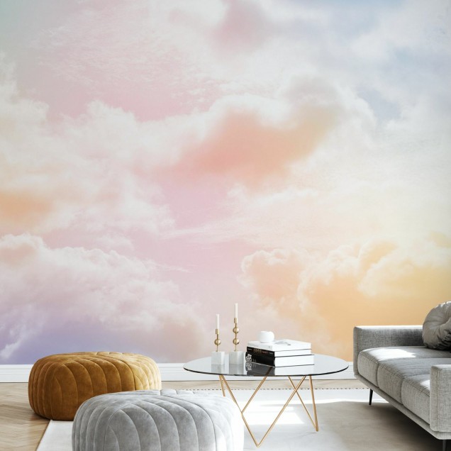 Imaginea de fundal Clouds in the Sky, prezintă nori albi pufoși pe un fundal colorat pastelat, care se transformă de la roz la galben, în timp ce lumina soarelui se reflectă ușor prin ei.