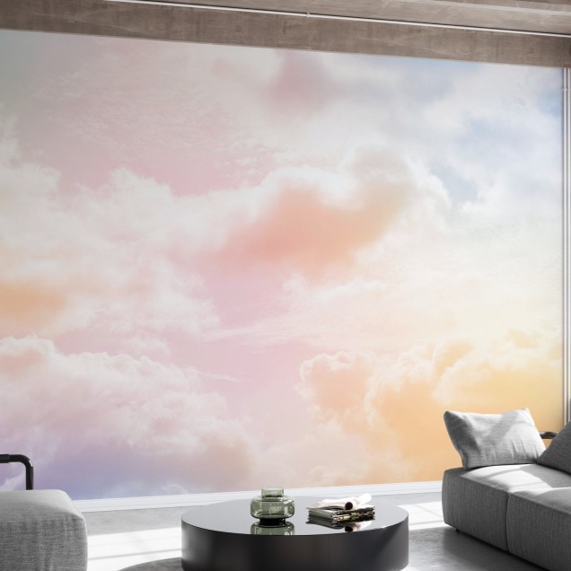 Imaginea de fundal Clouds in the Sky, prezintă nori albi pufoși pe un fundal colorat pastelat, care se transformă de la roz la galben, în timp ce lumina soarelui se reflectă ușor prin ei.